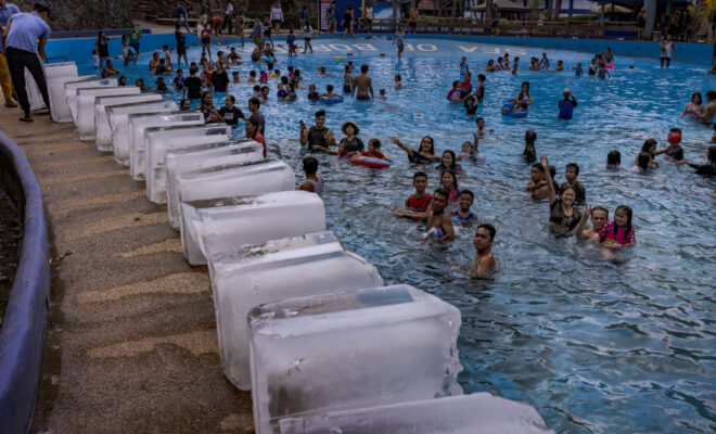MARILAO, PHILIPPINES - MAY 04, 2024: Workers prepare to dump blocks of ice at a pool amid extreme heat in Marilao, Bulacan province. Sweltering conditions strained power grids, sparked health warnings, and left residents desperate for ways to stay cool. May 2024 was the world's warmest May on record. (Image credit: Ezra Acayan/Getty Images)